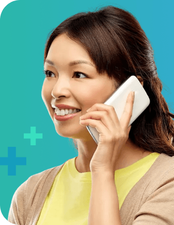A woman smiling while speaking with a doctor over the phone.